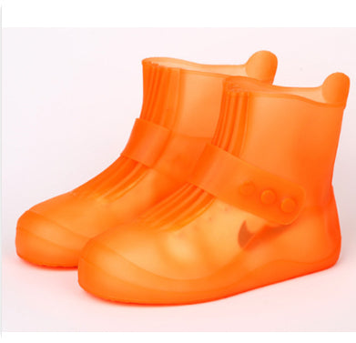 Orange rain boots with a strap on a white background