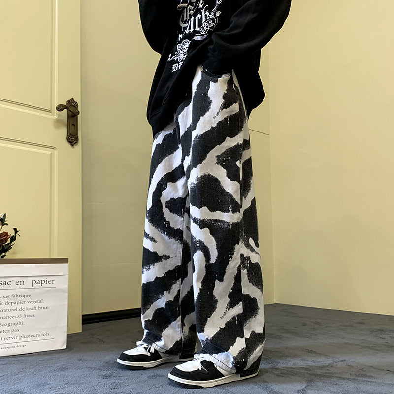 Person wearing a black and white patterned outfit with sneakers in a room.