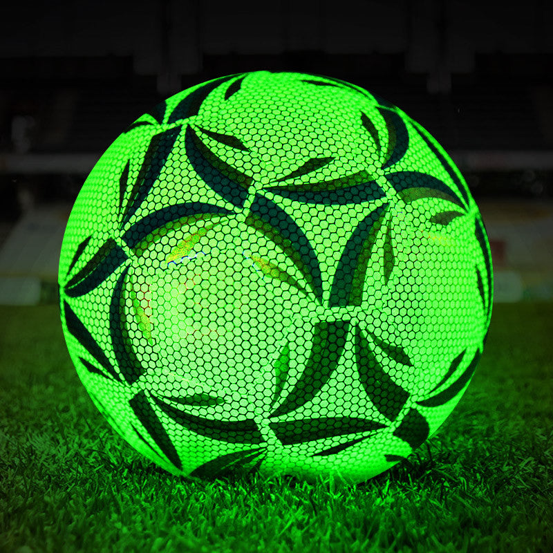 Green soccer ball with black patterns on grass