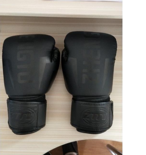 Pair of black boxing gloves on a wooden surface