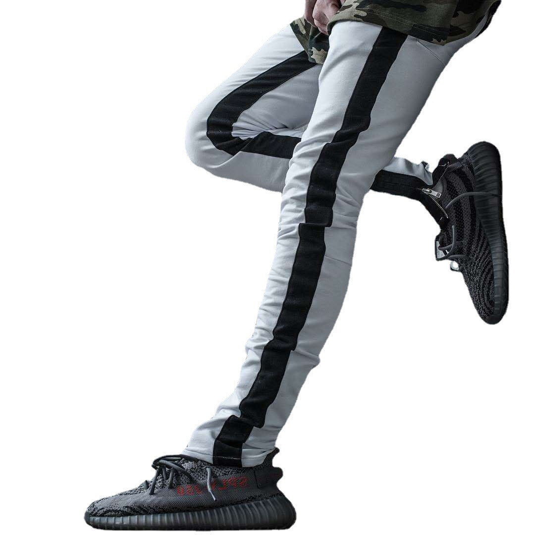 White pants with black stripes worn by a person on a white background