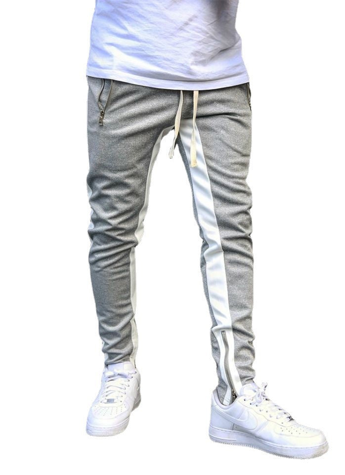 Gray jogger pants with white stripes and white sneakers on a white background