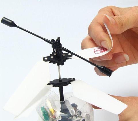 Hand applying tape to a small mechanical device on a white background