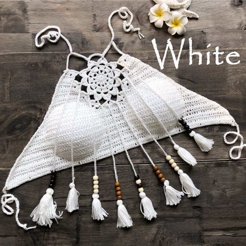 White crochet top with tassels on a wooden surface, labeled 'White'.