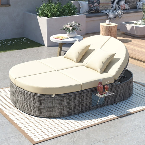 Outdoor lounge chair with cushions on a patio area with a small table and plants.