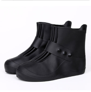 Black rubber rain boots with buttons on a white background