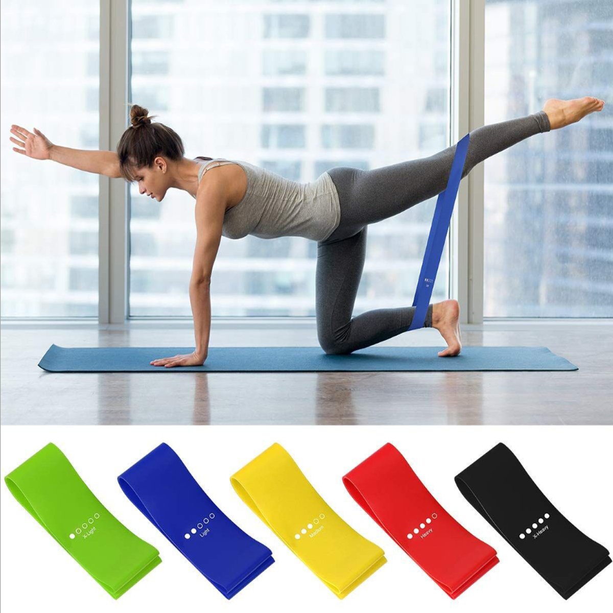Woman exercising with a resistance band in a room with large windows