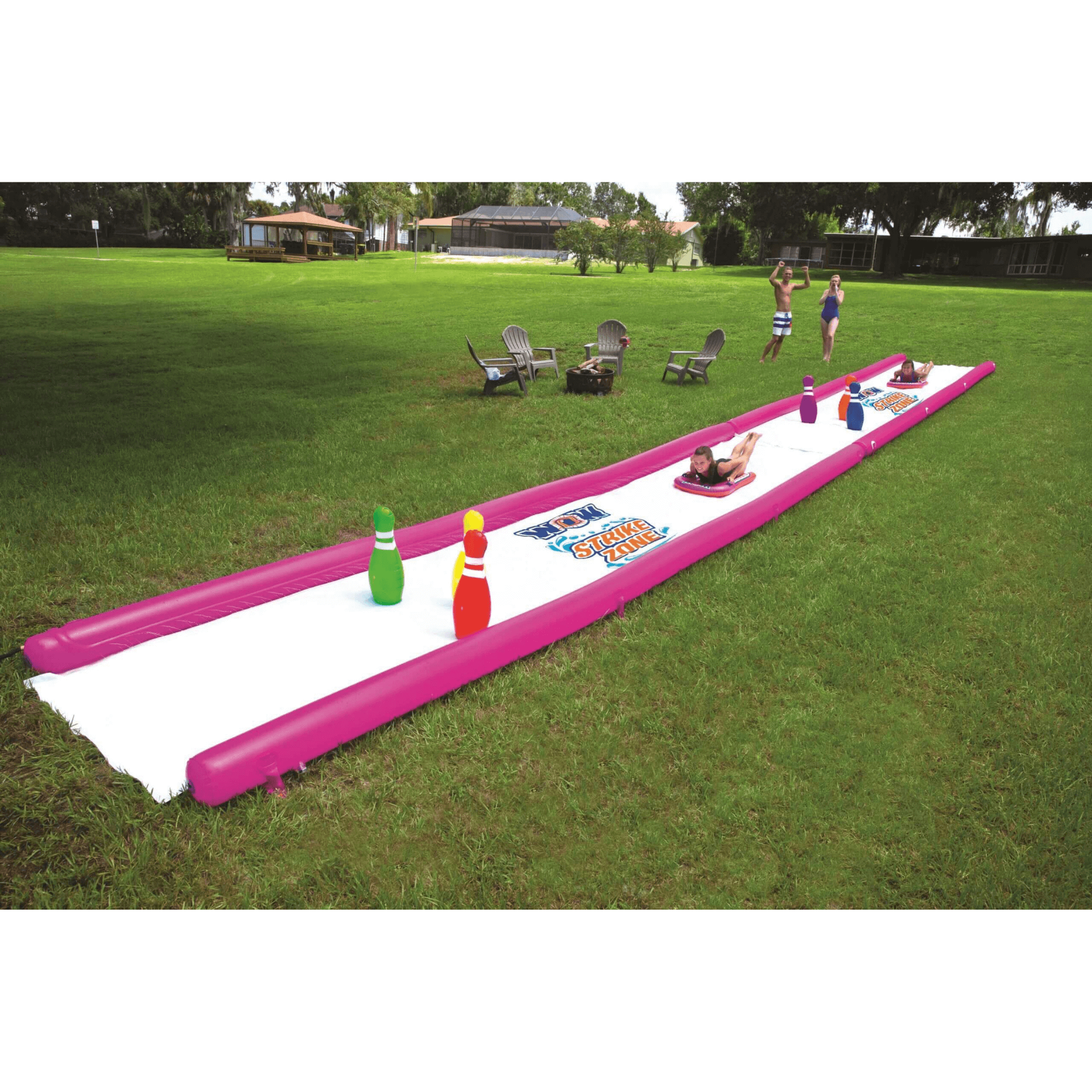 Inflatable water slide with bowling pins on a grassy field