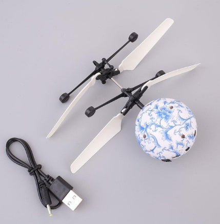 Small drone with propellers and USB cable on a gray background