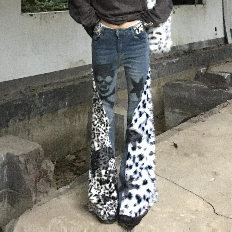 Person wearing leopard print boots and blue jeans standing on a concrete surface.