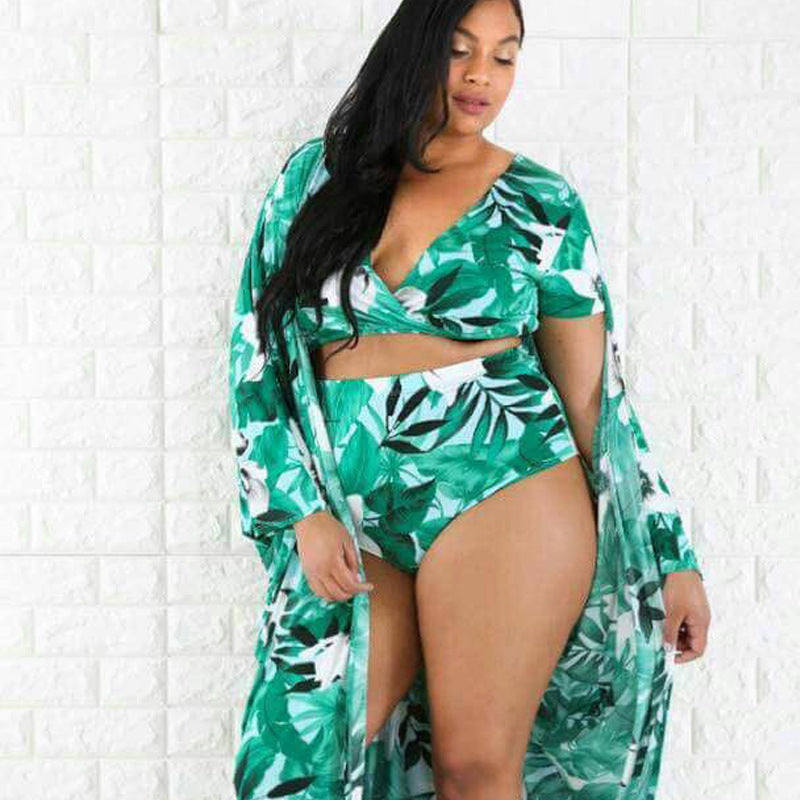 Woman wearing a green leaf-patterned swimsuit with a matching cover-up against a white background