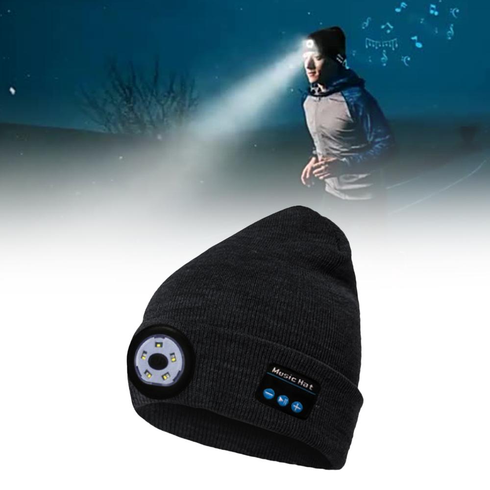 Black beanie with LED light and Bluetooth speaker on a snowy background
