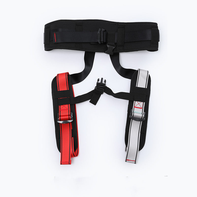 A black industrial lifting harness laid flat on a white background, featuring red and silver webbing straps with black plastic buckles.