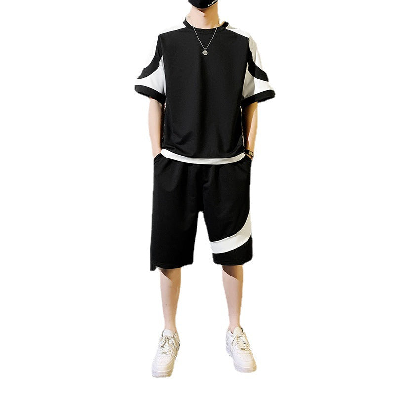 Person wearing a black and white outfit with shorts on a white background