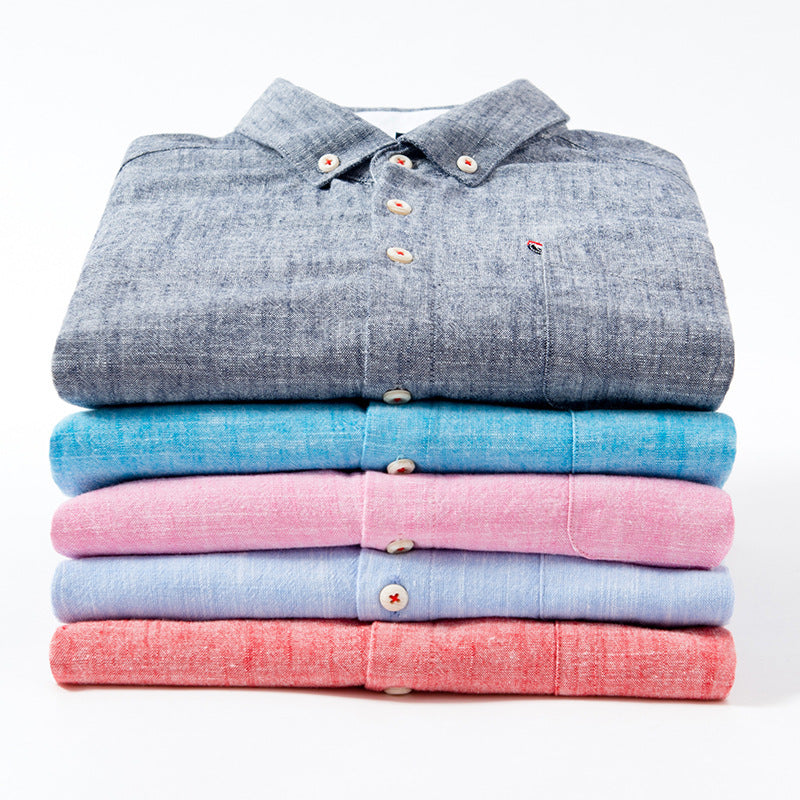 Stack of folded shirts in gray, blue, pink, and red on a white background