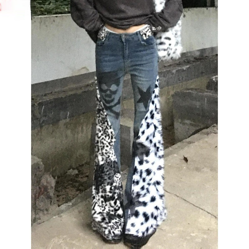 Person wearing blue jeans with star patterns and leopard print cuffs on a concrete surface.