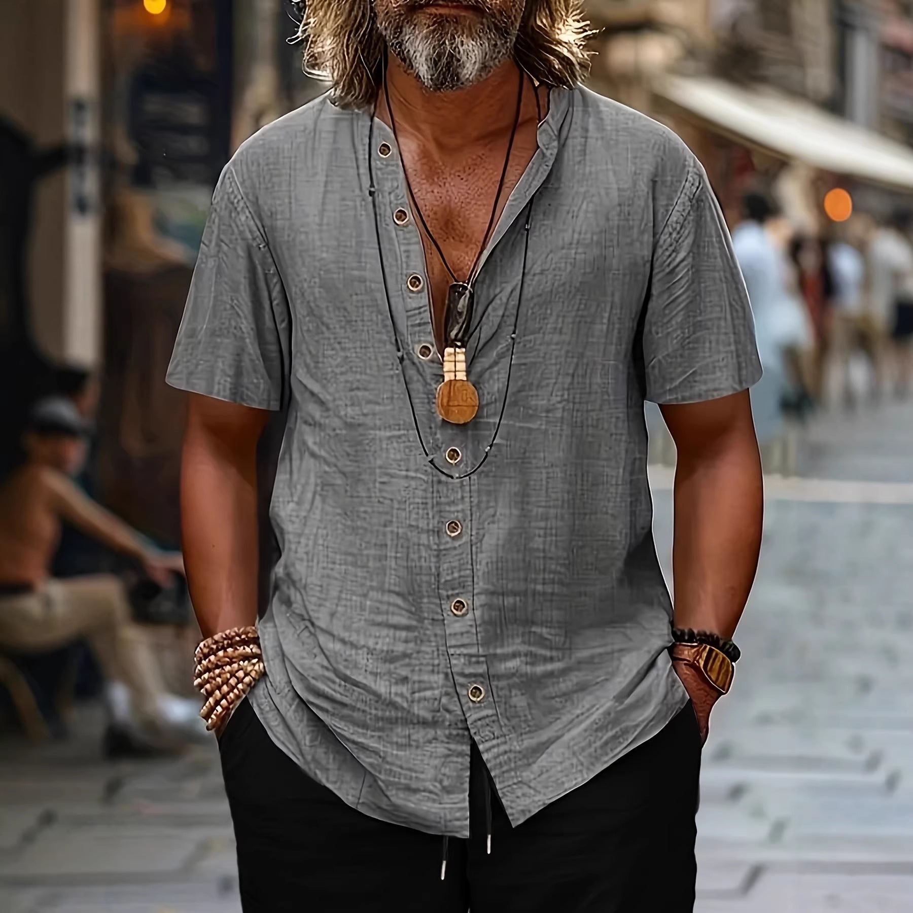 Man wearing a gray shirt with a necklace on a blurred street background