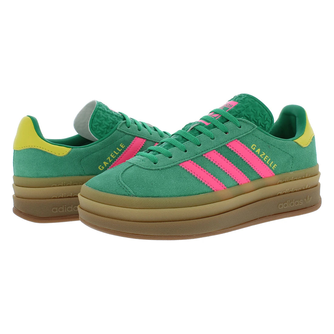 A pair of Adidas Gazelle sneakers in green suede with bright pink stripes, a yellow heel tab, and a thick brown gum sole, shown against a plain white background.
