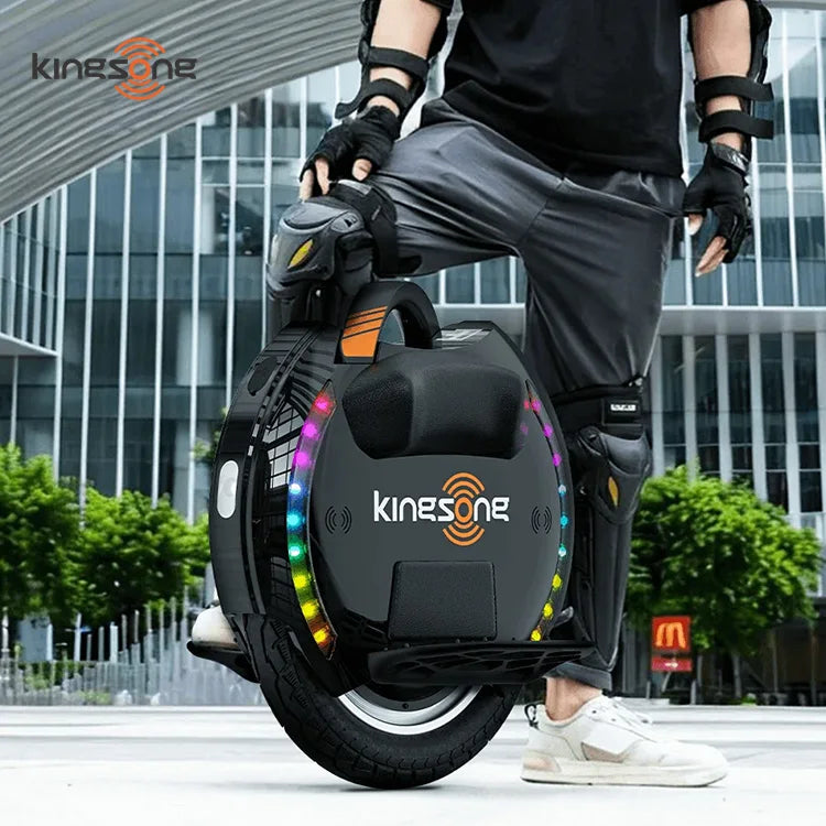 Rider wearing protective pads beside a black KingSong electric unicycle with multicolor side lights.