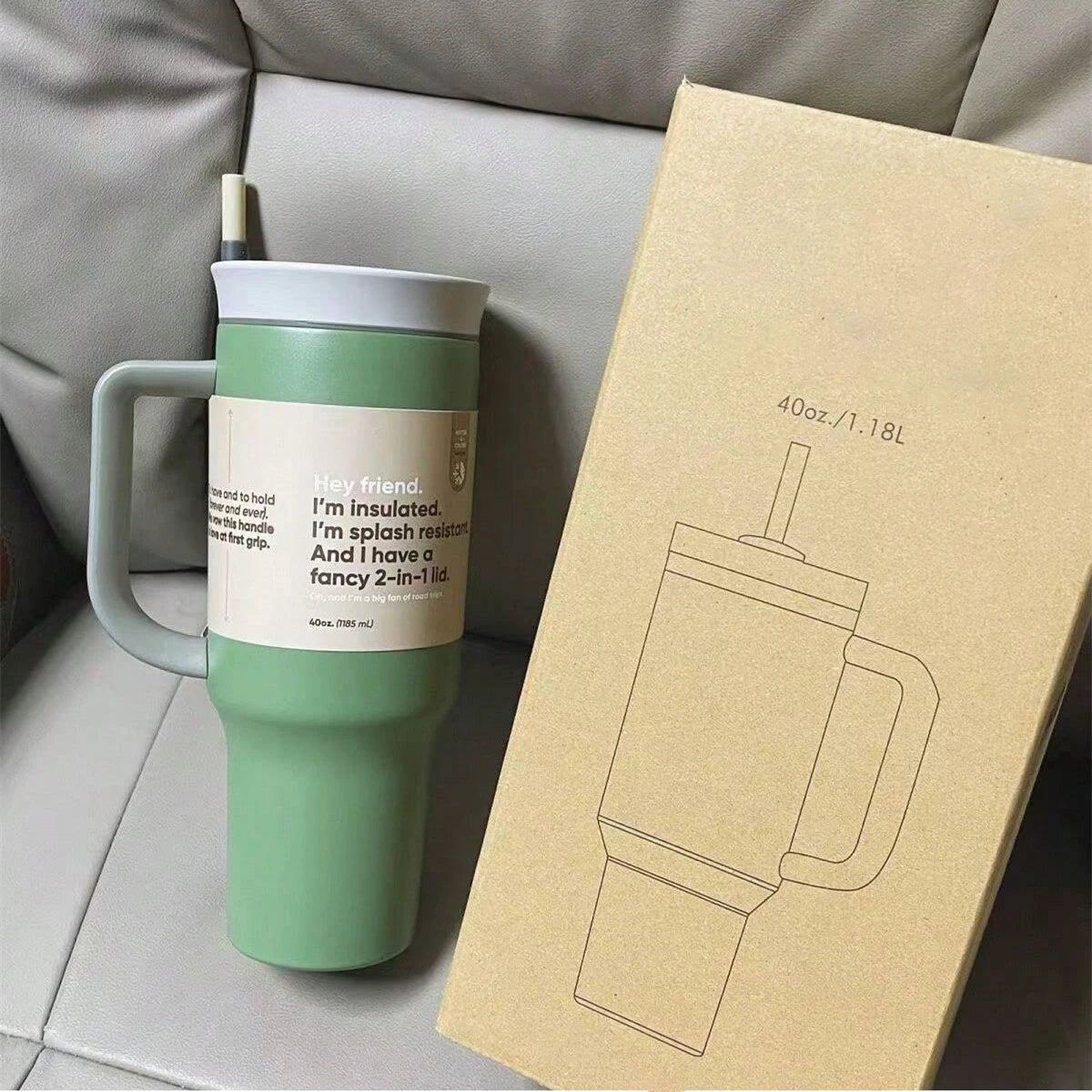 Green 40 oz travel tumbler with gray handle, lid and straw beside a cardboard product box