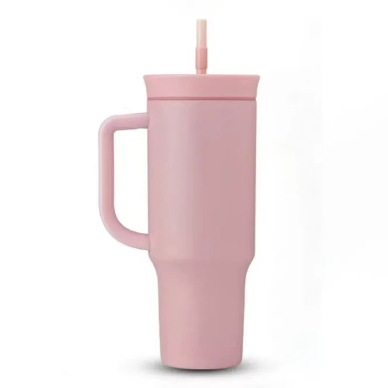 Pink travel tumbler with matching handle, lid and straw on a white background.