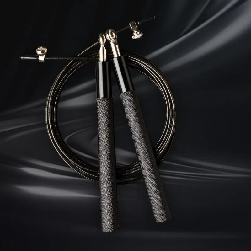 Black jump rope with black handles on a dark background