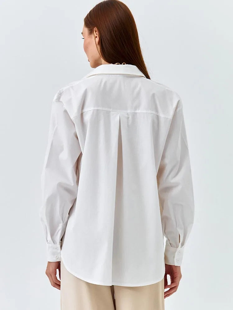 Person wearing a white shirt on a plain background