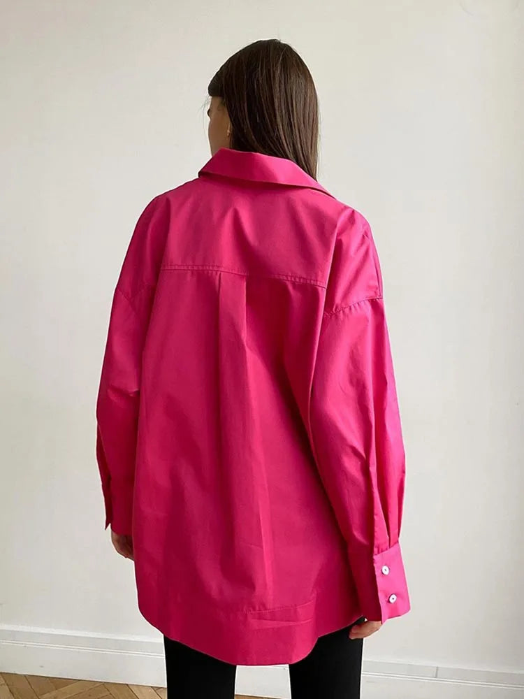 Person wearing a bright pink jacket against a plain background