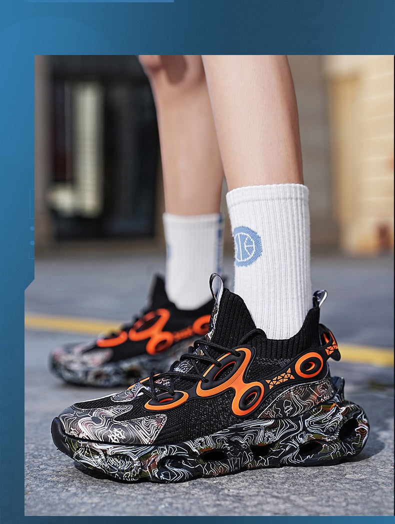 Black and orange sneakers with a unique design worn by a person on a blurred street background