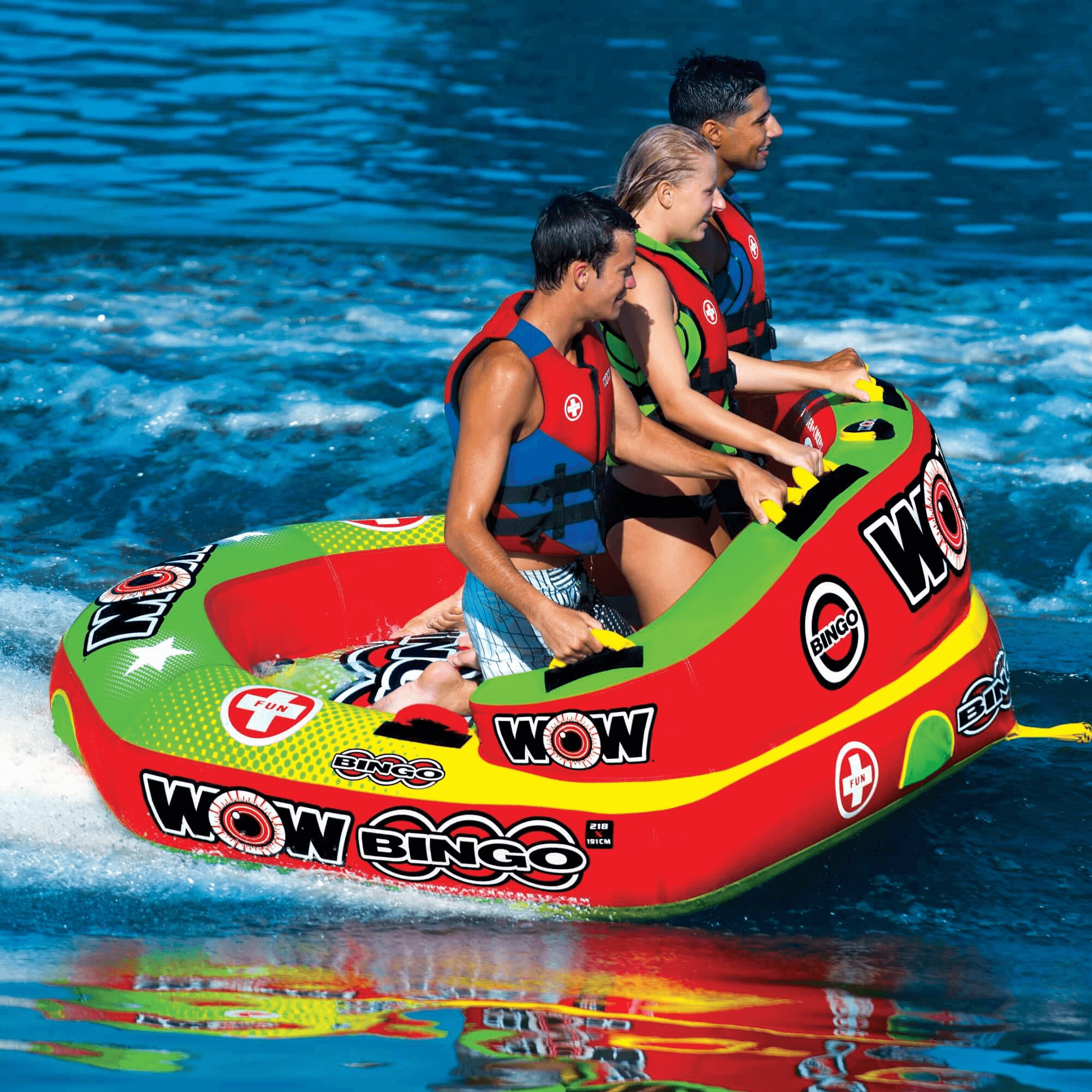 Three people on a colorful inflatable tube in the water with 'WOW' branding.