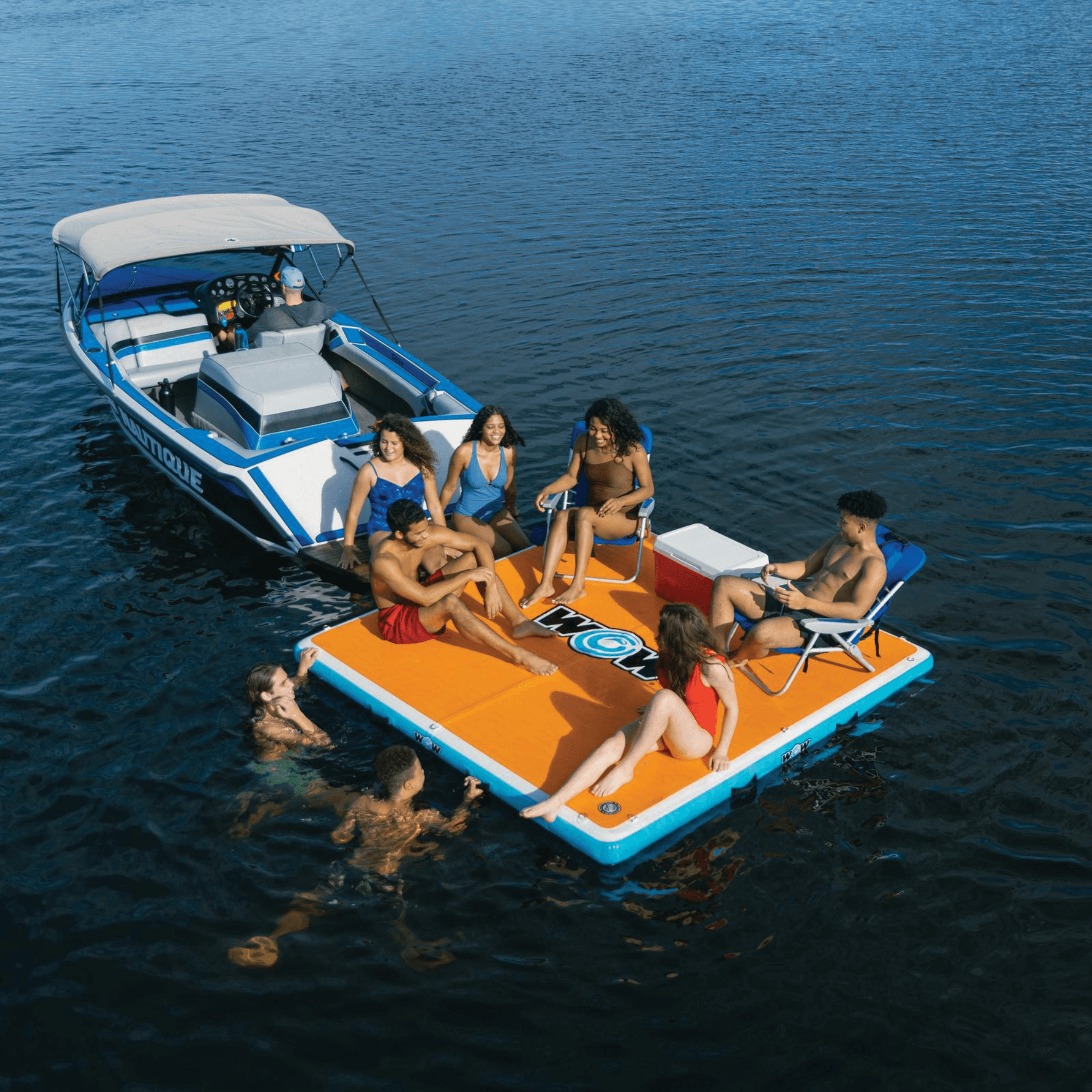 Group of people on an inflatable platform attached to a boat in the water