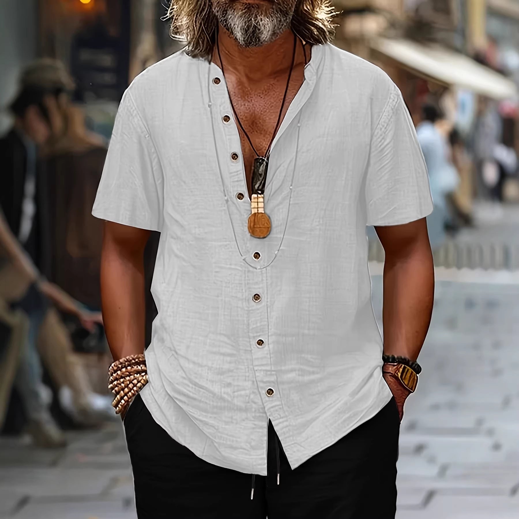 Man wearing a white short-sleeve shirt with buttons and black pants on a blurred street background
