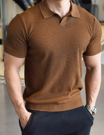 Man wearing a brown knitted polo shirt with a blurred background