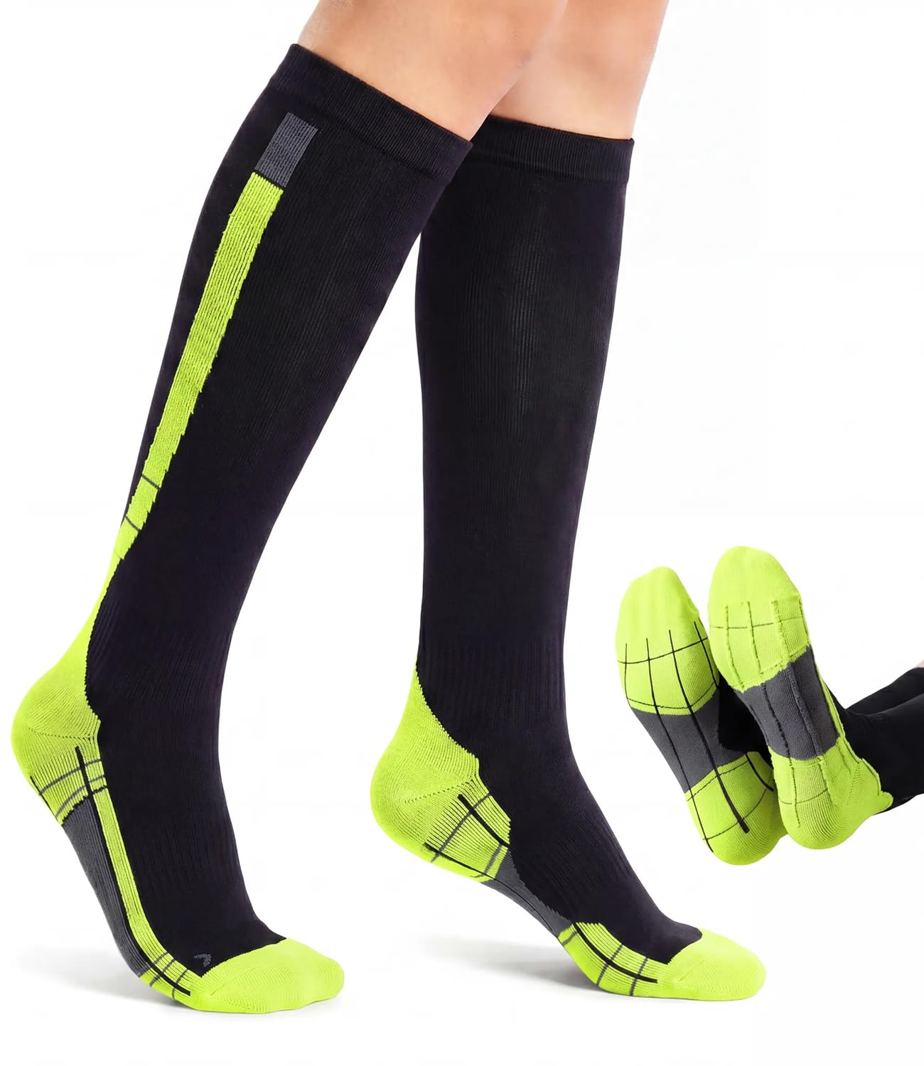 Black knee-high compression socks with bright neon yellow-green accents on the toe, heel, and side panels, shown worn on legs with a separate pair displayed on a white background.
