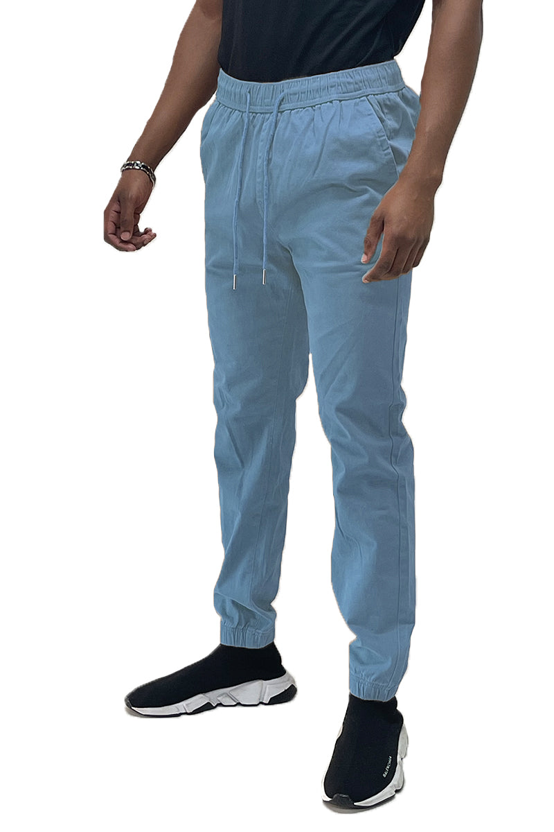 Light blue jogger pants worn by a person on a white background