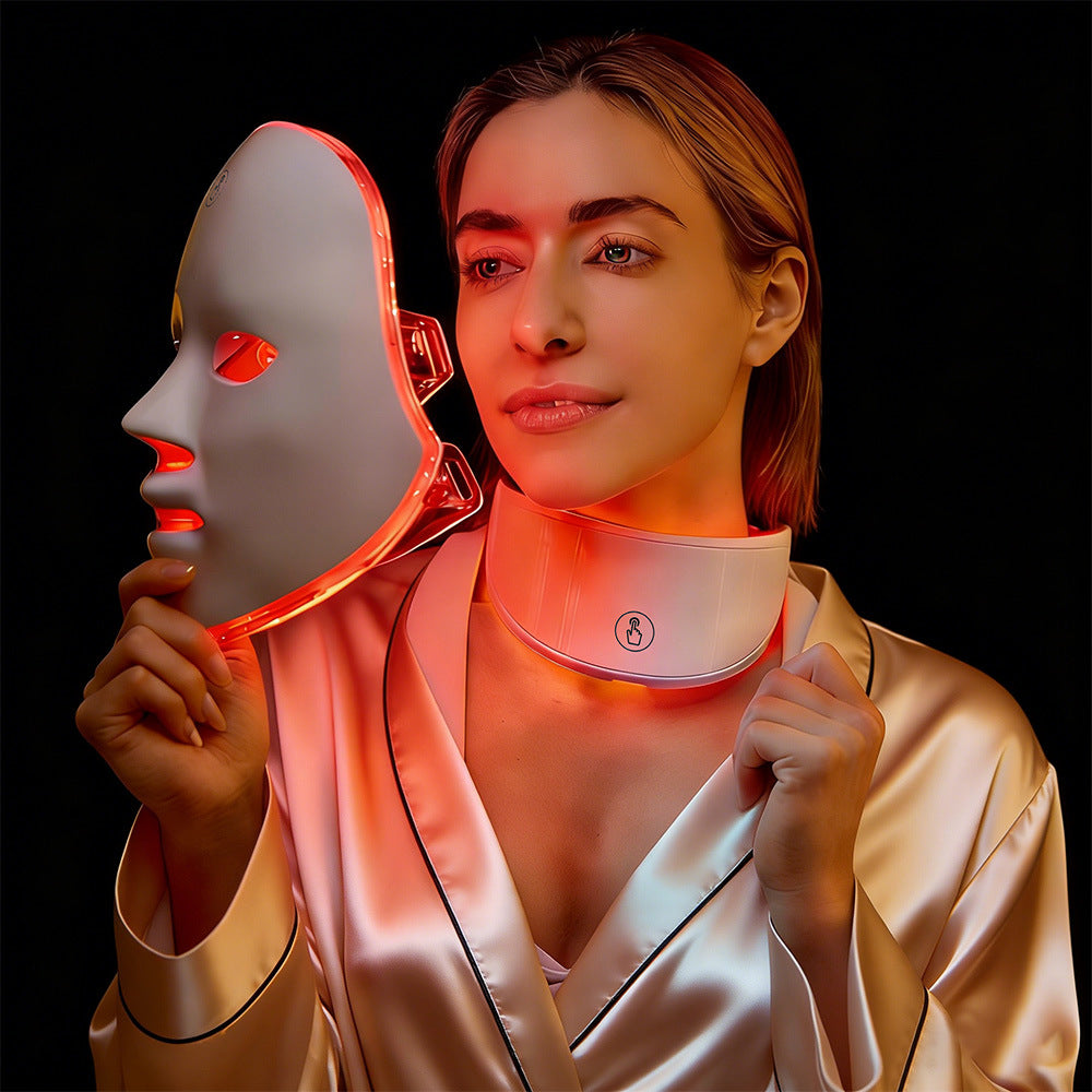 Woman wearing a LED face and neck mask with a black background