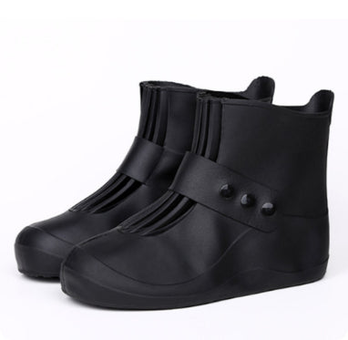 Black rain boots with button details on a white background
