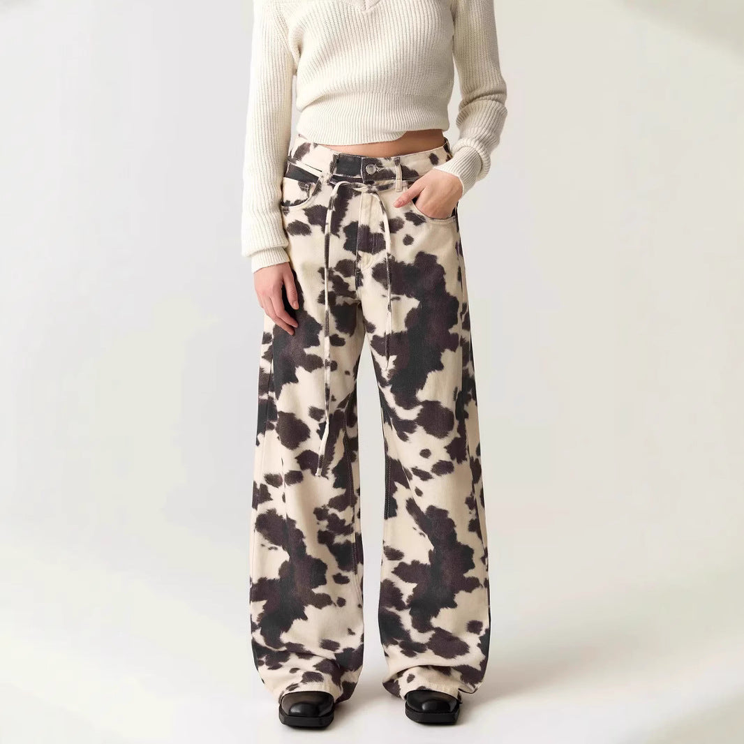 Person wearing cow print pants on a white background