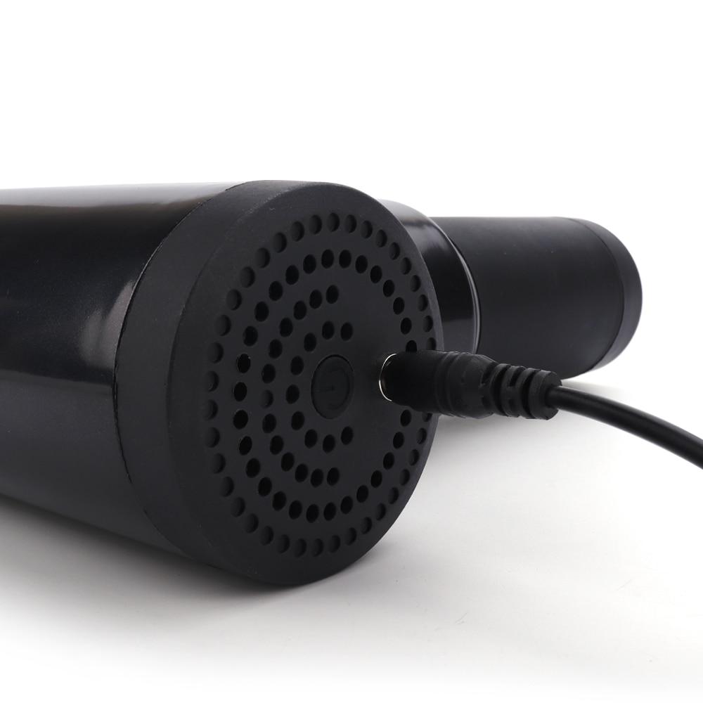 Black cylindrical device with a textured surface and power cord on a white background