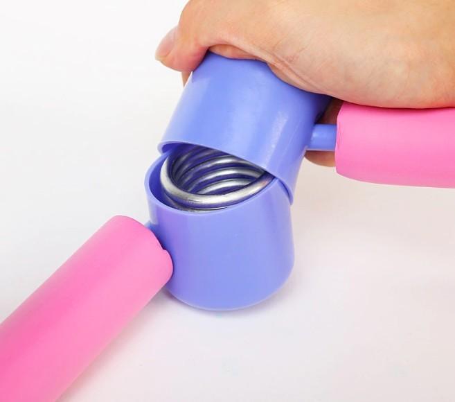 Hand holding a pink and purple exercise device