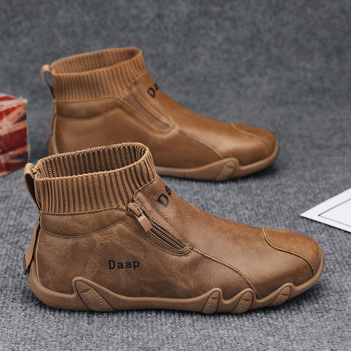 Brown ankle boots with a visible brand logo on a gray surface