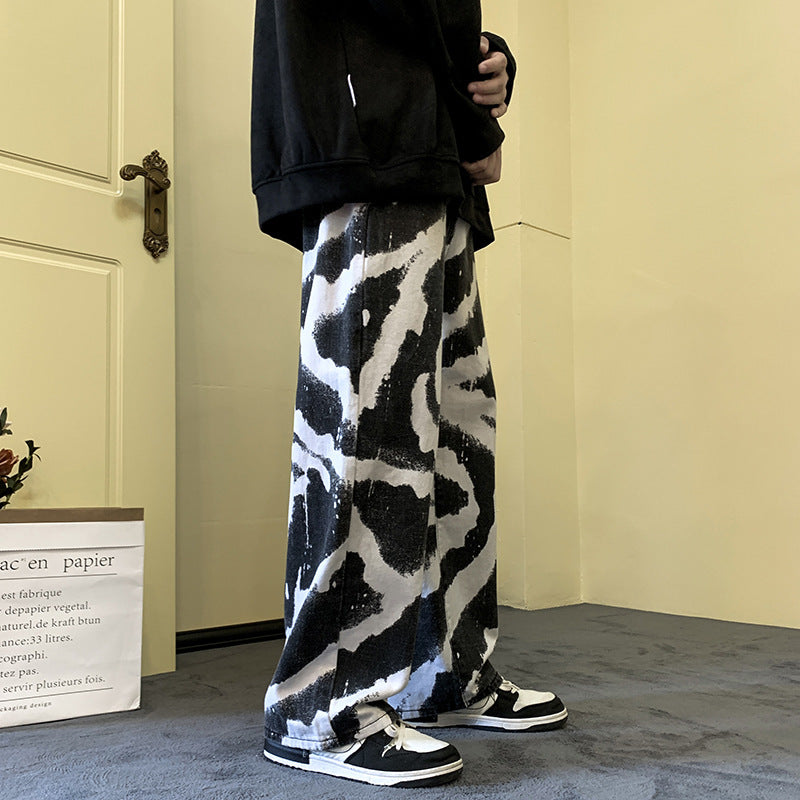 Person wearing black and white patterned pants with a plain background