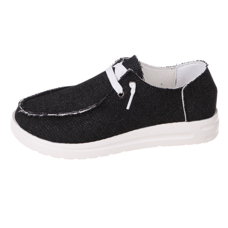 Black casual shoe with white laces on a white background