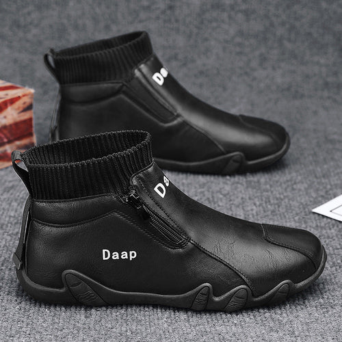 Black ankle boots with 'Daap' branding on a gray surface