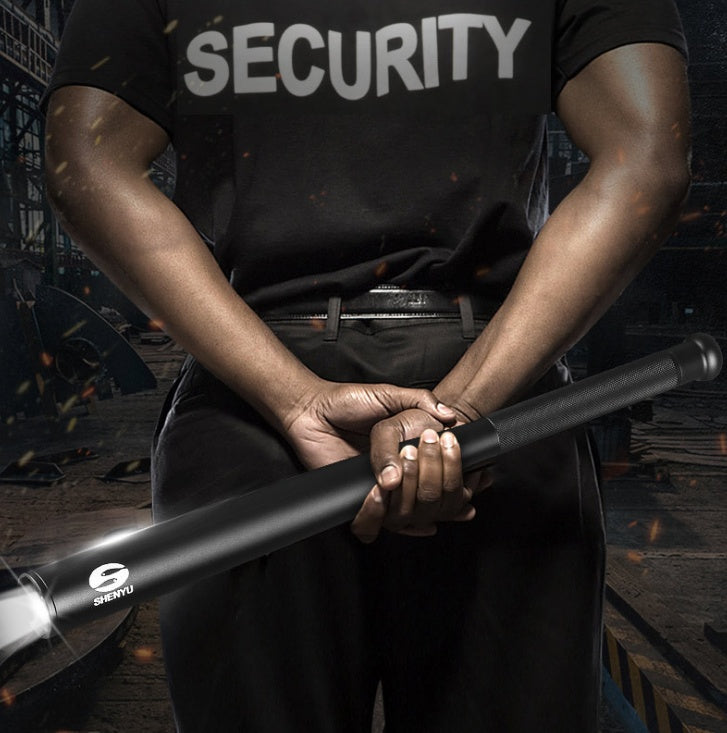 Person wearing a black 'SECURITY' shirt holding a flashlight with a brand logo.