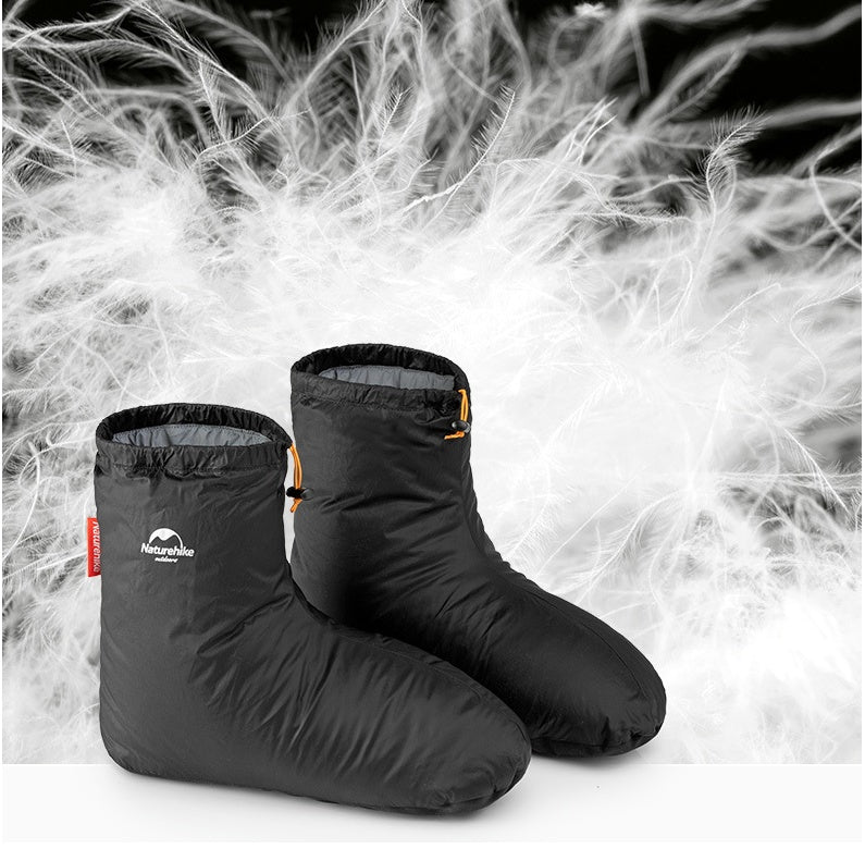 Black boot covers on a snowy ground with a brand logo.