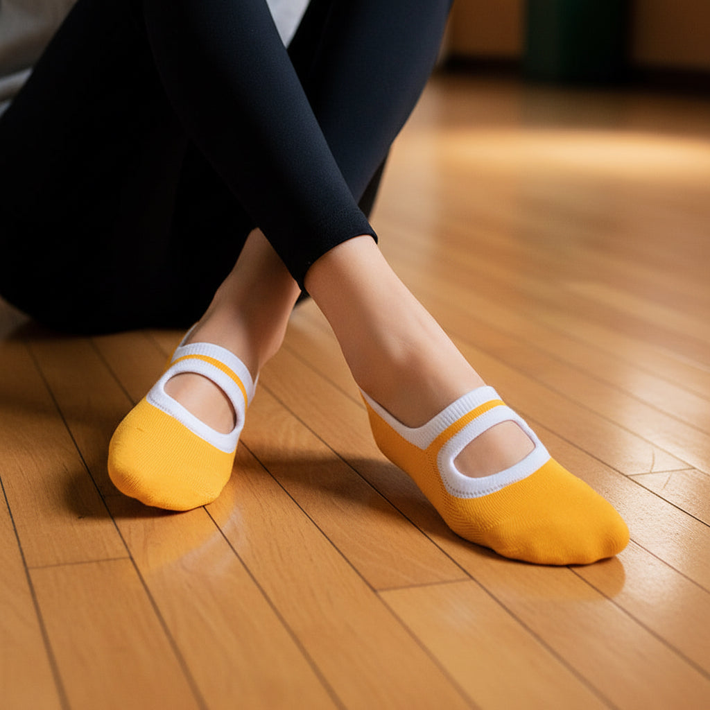 Orange socks with white straps worn by a person on a wooden surface in gymnasum.