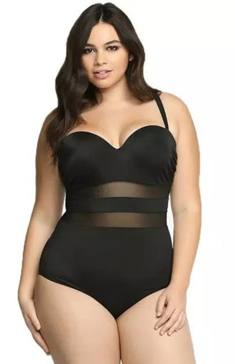 Woman wearing a black bodysuit with sheer panels on a white background