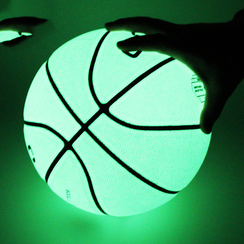 Glowing basketball held by a hand against a green background