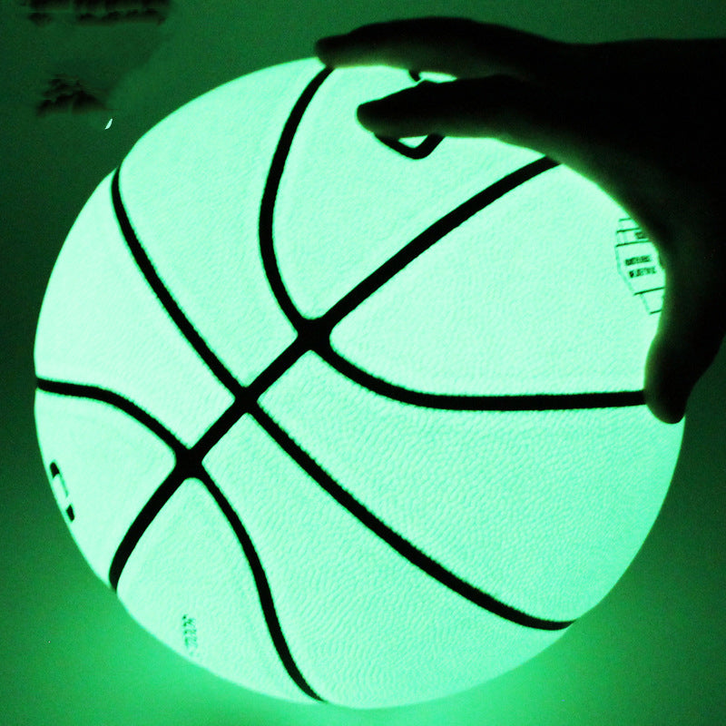 Glowing green basketball held by a hand against a dark background
